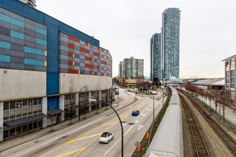 Overhead view of an urban street with a commuter train and high-rise towers in New Westminster, Vancouver, BC, Canada.